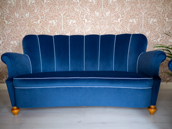 Vanhan sohvan uusi verhoilu sinisellä samettikankaalla.