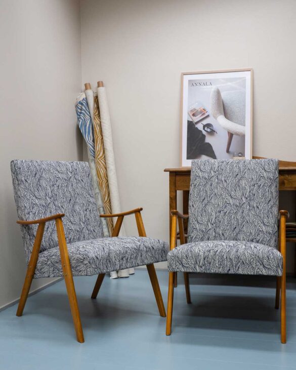 Kaksi 50-luvun kevyttä nojatuolia uudelleenverhoiltuna sinivalkoisella kuviollisella villakankaalla.