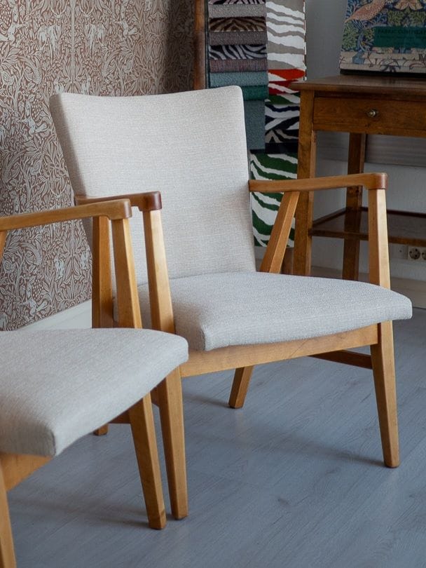 Vanhat 1950-luvun kevyet lepotuolit verhoiltuna uudella vaalealla huonekalukankaalla.