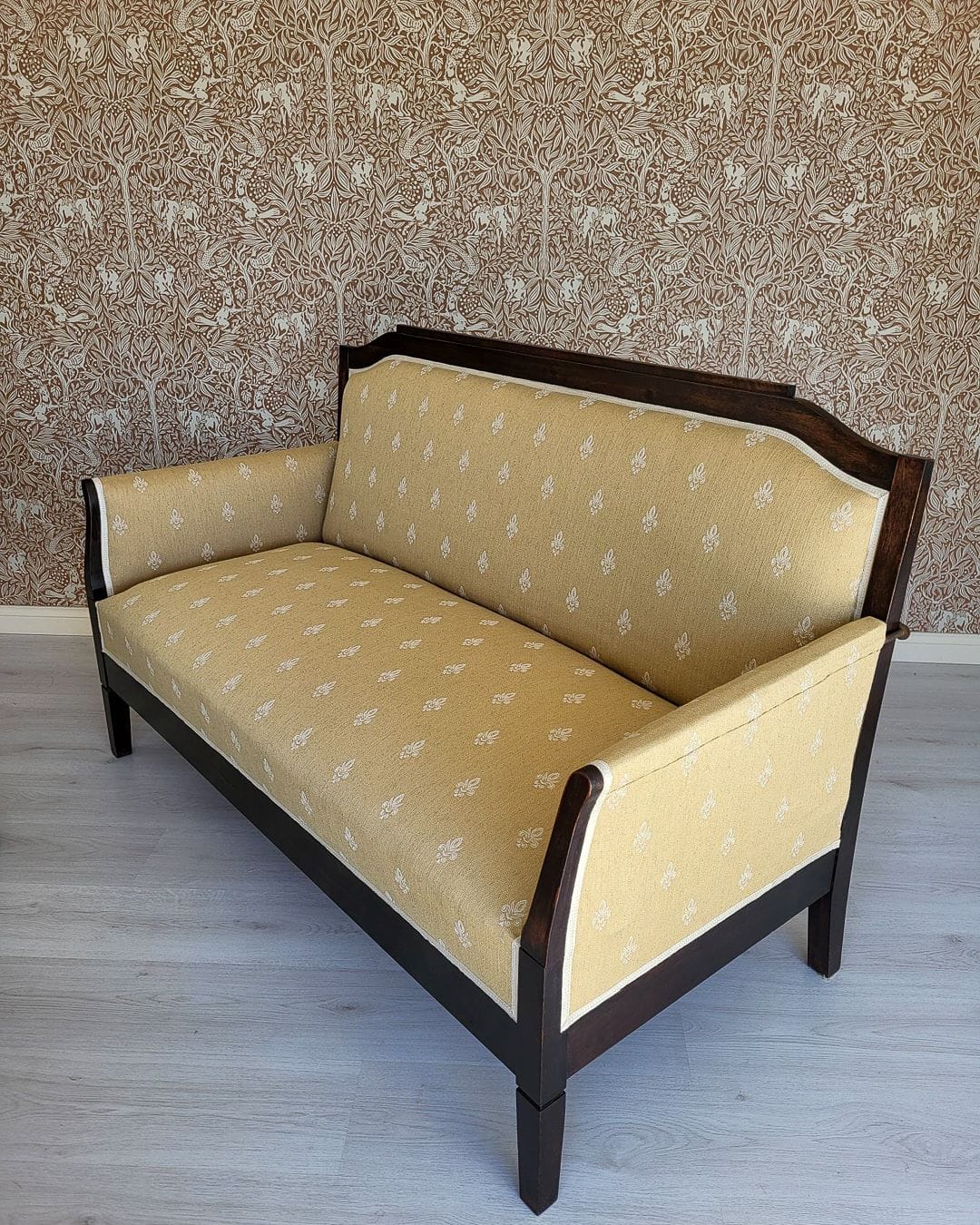 Vanha talonpoikaissohva uudella keltapohjaisella Annalan huonekalukankaalla.